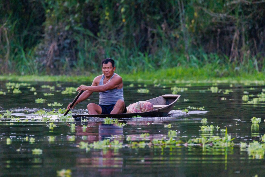 Indigener Mann im Einbaum in Peru